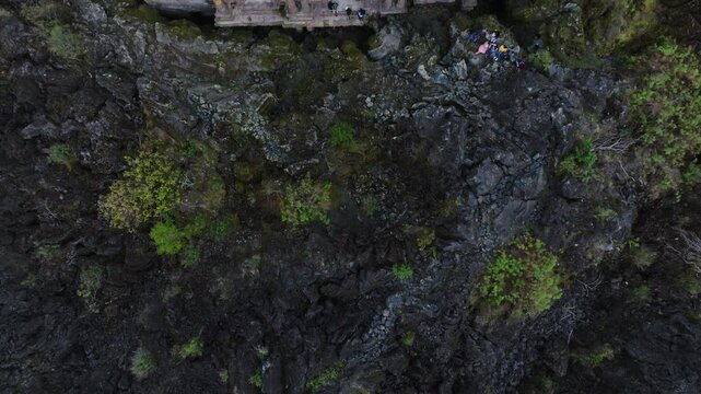 A dramatic bird's-eye view of the Ruinas de San Juan Parangaricutiro, Michoacan, Mexico, buried beneath cooled lava from a volcanic eruption, showcasing the eerie and powerful aftermath.