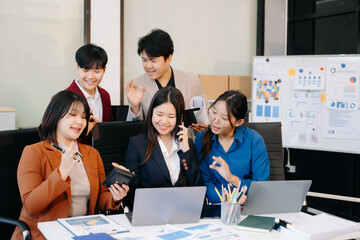 Group of diverse businesspeople using a laptop and tablet in office.