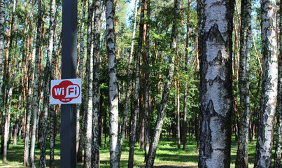 Red and white sign distributing free Wi-Fi in the park 
