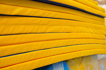Stacked bright yellow foam mats in a training facility ready for use during gymnastics practice