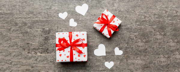Valentine day composition Background: red gift box with bow and heart. Christmas present. View from...