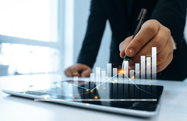 Business growth graph chart. Businessman using tablet analyzing sales data and financial...