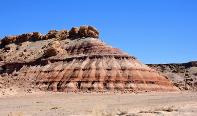 A colorful,  eroded  bentonite mesa  and a  sandy wash on a sunny spring day  along a four wheel drive road near  fossil point in the san rafael swell south of green river, utah