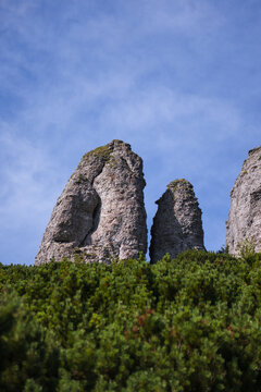 Tall Cliffs Rising On A Hill Covered With Bushes  In The Ceahlău Massif (Masivul Ceahlău), Blue Sky With Clouds