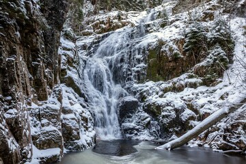 Obraz premium Serene Winter Waterfall in Snowy Forest