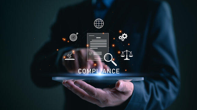Compliance in business concept. Laws concept. Enforce laws, regulations and standards, comply with business policies, Businessman use tablet with compliance icon on virtual screen.