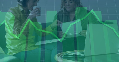 Financial graph image over people discussing business in office
