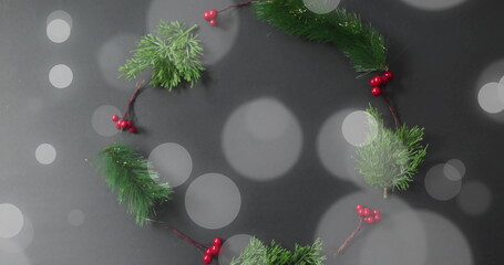 Christmas wreath with red berries and green pine branches over bokeh lights image © vectorfusionart