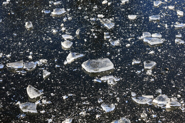 Broken ice crystals scattered on black surface