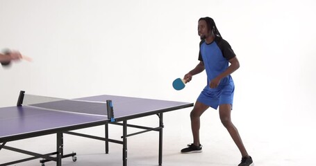 African american male table tennis player serving and passing the ball on white background - Powered by Adobe