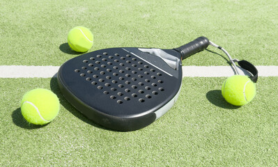 paddle tennis racket and balls on court