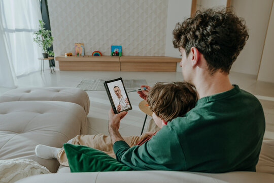 Father and son talking on video call at home