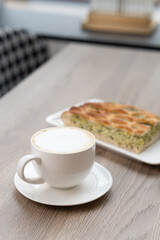 A piece of spinach pie on a plate on a table in a cafe