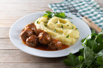 Meatballs with mashed potatoes on wooden table
