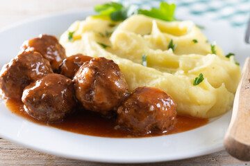 Meatballs with mashed potatoes on wooden table. Close up