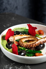 Salad of fried octopus with greens and vegetables