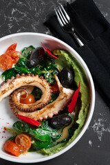 Salad of fried octopus with greens and vegetables