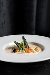 Creamy seafood soup in a white bowl in a restaurant close-up