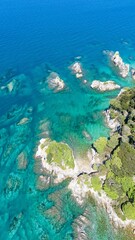 Aerial view of turquoise coastline with rocky outcrops.