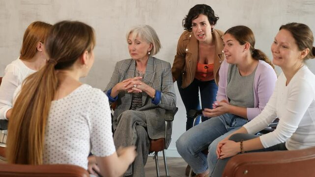  Women communicate while sitting on chairs in circle 