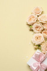 Beautiful composition with peony roses and gift box on color background