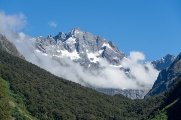 Majestic mountain peak with snow and clouds