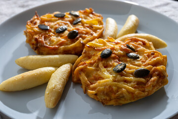 Pumpkin grated roasted patties, rosti or latkes and Fingernudel, finger potato noodle, dumplings decorated with pumpkin seeds