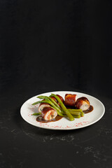 Stuffed rolls and asparagus as decoration. Restaurant dish on a white plate