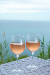 Summer time in Provence, two glasses of cold rose wine with blue sea view on background, French Riviera near Menton, south of France