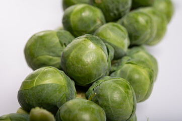 Green brussels sprouts on stalks on white table