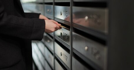 Close up woman inserting letter in mailbox. Mail delivery. Mail shipping concept.
