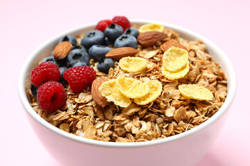 Delicious granola with berries on a color background