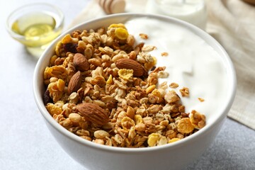 Delicious granola with yogurt on a gray background