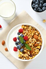 Delicious granola with berries and yogurt on a light background