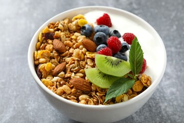 Delicious granola with berries and yogurt on a light background