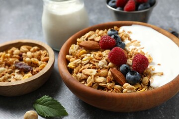 Delicious granola with berries and yogurt on a gray background