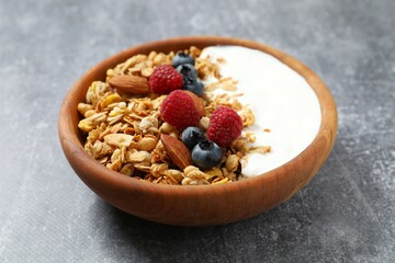 Delicious granola with berries and yogurt on a gray background