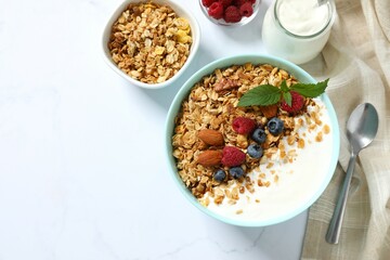 Delicious granola with berries and yogurt on a light background