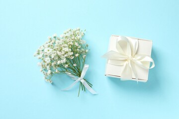 Top view photo with gypsophila flowers and gift box on color background 