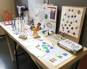 A school science fair table with creative models, charts, and neatly displayed projects