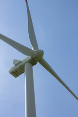 Wind turbines on a sunny day against a blue sky, an alternative wind energy source that can produce electricity both day and night