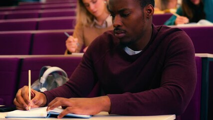 Dedicated university student concentrating while writing notes during lecture, capturing studious learning moment through slow motion montage with multiple perspectives
