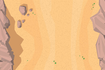 Top view of desert landscape with a sandy expanse and subtle texture. Features rugged cliffs on both sides, scattered rocks, and small green bushes. Aerial. View from above.