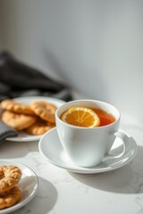A cup of tea with lemon and cookies on a marble table. Sunlight streams in, creating a warm and inviting atmosphere.