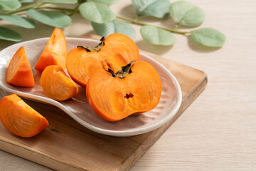 Fresh ripe persimmon fruit on wooden table background.