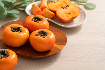 Fresh ripe persimmon fruit on wooden table background.