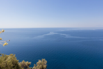 Stunning view of a rugged coastline with vibrant blue sea and rocky cliffs under clear skies.