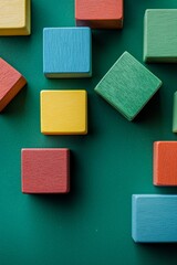 Fototapeta premium Colorful wooden building blocks on a green background