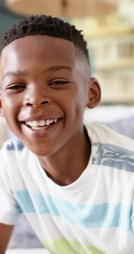 Vertical video: Smiling boy in striped shirt enjoying family lunch at home