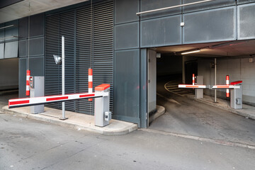 Modern parking garage entrance featuring automated barriers, security measures, and a streamlined urban infrastructure